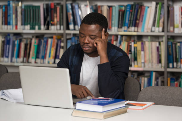 istock Confused Male Student Reading Many Books For Exam 1263478015