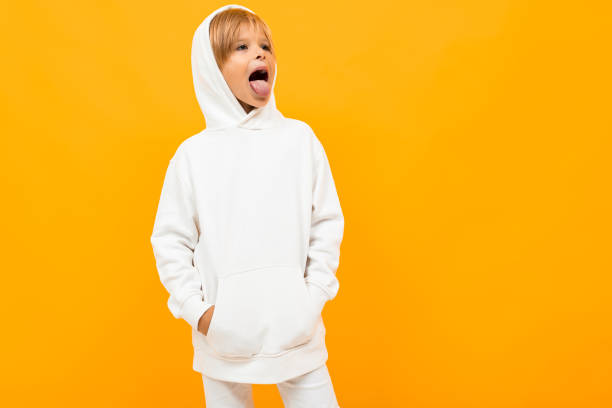 istock attractive blond boy in a white sweater is grimacing on an orange background 1263478050