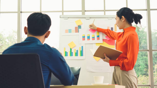 istock Young woman explains business data on white board 1263481210