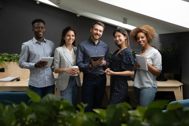 istock Portrait of successful diverse employees team holding electronic devices 1263481521