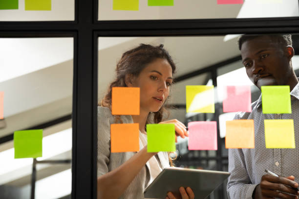 istock Mentor explaining project plan on stickers to African American trainee 1263482041