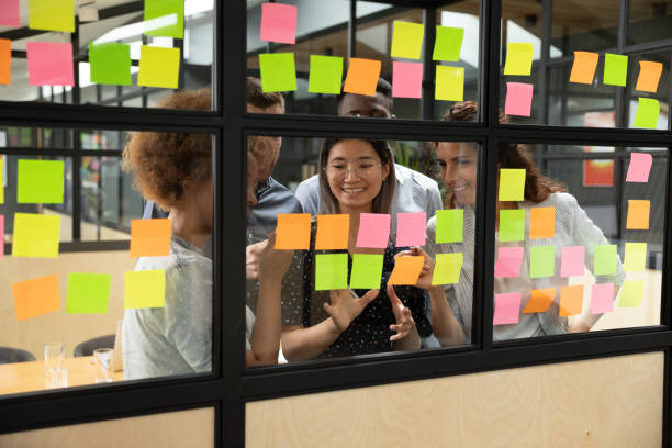 istock Happy diverse colleagues planning project, writing on stickers together 1263482054