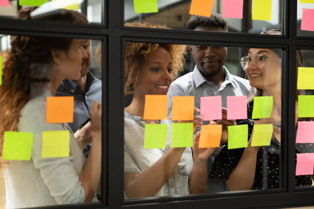 istock African American leader with team writing ideas on sticky papers 1263482055