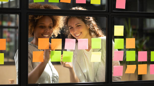 istock Smiling diverse colleagues discussing creative ideas on sticky papers 1263482056