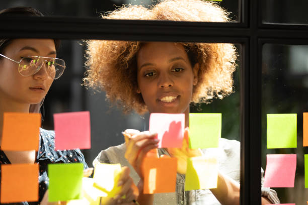 istock African American mentor explaining strategy on sticky papers to employee 1263482057