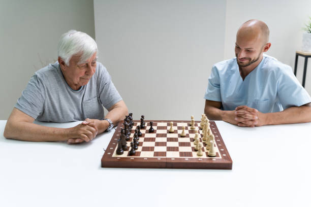 istock Elderly Senior Playing Chess With Caregiver 1263484018