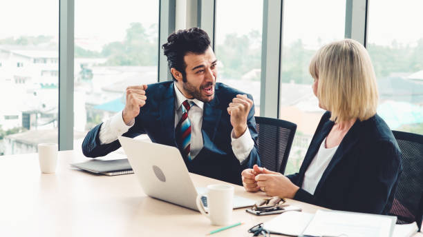 istock Two happy business people celebrate at office 1263487524