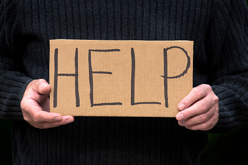 Handmade cardboard sign asking for help, pleading, begging, desperate, cry for help