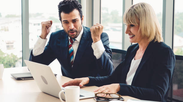istock Two happy business people celebrate at office 1263489142
