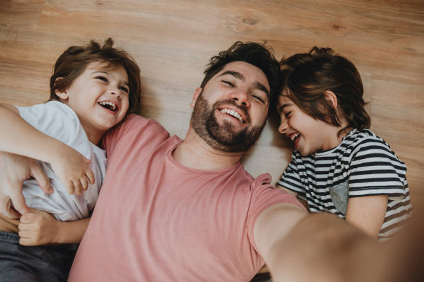 istock Father having fun with kids and making selfie at home 1263490098
