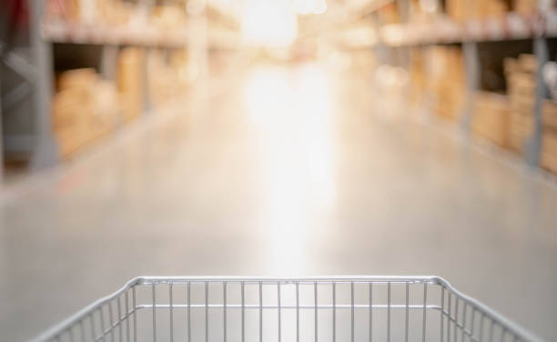 istock Blurred effect in the big warehouse aisle with empty silver and blue shopping trolley 1263496426