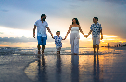 Hispanic family walking on empty beach Florida