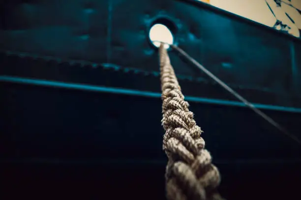 Photo of Rope that tied the ship close-up on the background of the ship's side.