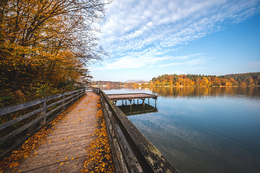Idyllic autumn scene with wooden jetty by the lake.