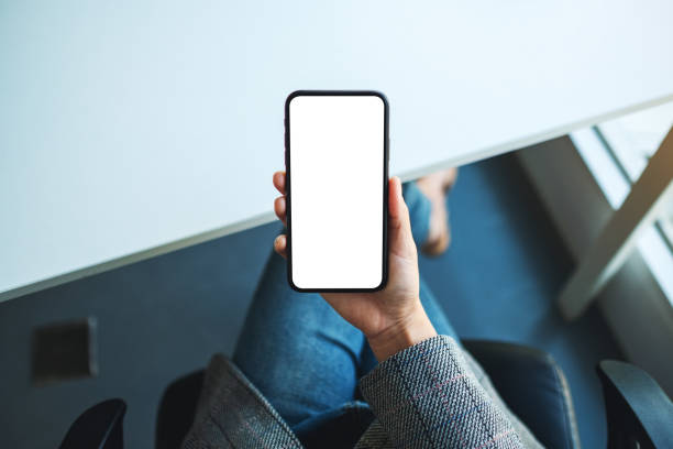 istock a woman holding mobile phone with blank white desktop screen 1263517189