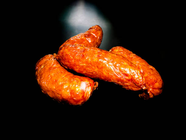 istock Smoked meat sausages on a black background. 1263517950