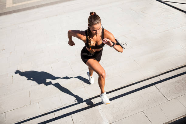 Young woman running up the steps in morning