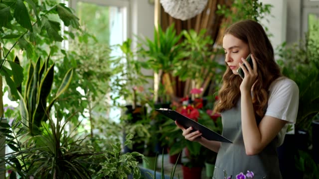 Female florist receives orders by the phone