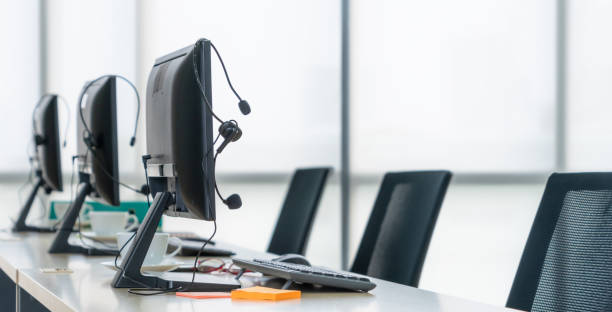 istock Call center computers and headsets all in office 1263521545