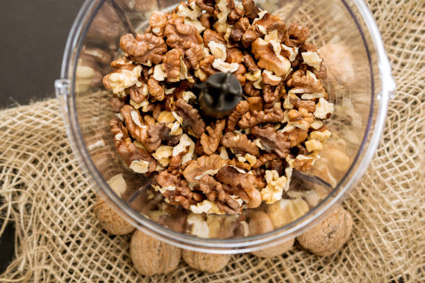 istock Tasty walnut kernels plastic container of a small kitchen blender. for a tasty dessert. 1263524364