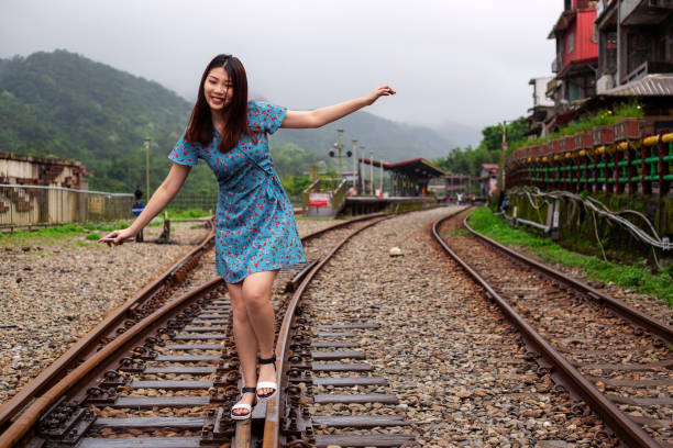 istock Shifen Old Streets - woman having fun balancing on  railway 1263525632