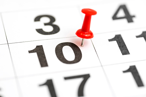 Pin on the date number 10. The tenth day of the month is marked with a red thumbtack. Pin on calendar. Calendar concept for important date, busy day, appointment or meeting reminder