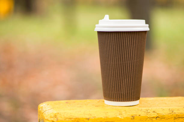 istock Coffee cup on wood table nature background in park , warm tone 1263525645