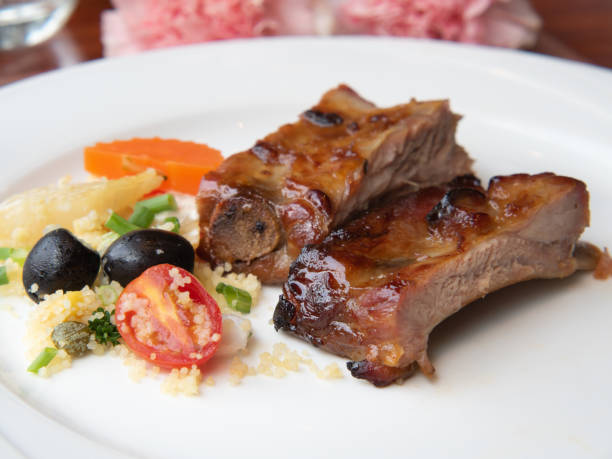 istock Pork ribs grilled with BBQ sauce and caramelized in honey served with a side dish on a white plate. 1263525663