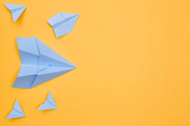 istock minimalism blue paper planes on a yellow background. travel, flight, flat layer, copy space one 1263527578