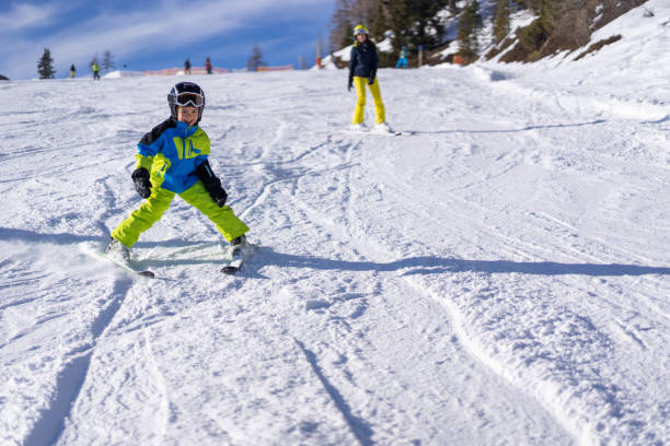 istock young boy skiing snowplow on ski slope 1263529539