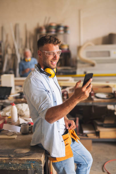 istock Woodworker looking at cellphone and laughing 1263533283