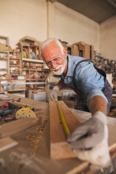 istock Cheerful male carpenter working with wood in his workshop 1263533424