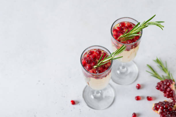 istock Pomegranate champagne rose with rosemary on white background 1263534929