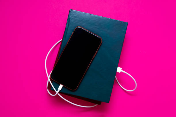 istock Smart phone connected to the old book with a cable, and download information from there 1263536847
