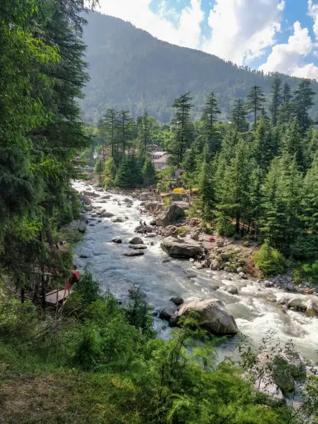 Manali, India - June 9th 2019: People Crossing river stream through ropes by rappelling in Manali Adventure Park.