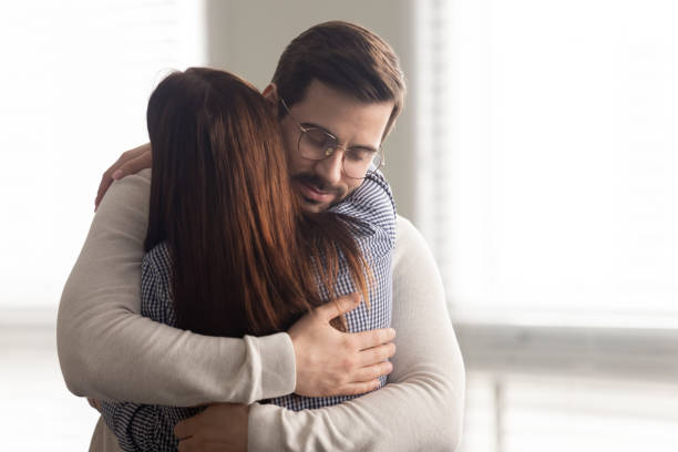 Handsome man embracing woman calms in difficult moment. Handsome man embracing woman calms in difficult moment. Husband hugging wife relieves stress from work or health. Friends and couple relationship concept. embracing stock pictures, royalty-free photos & images