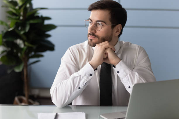 istock Thoughtful businessman using laptop, pondering online project. 1263543076