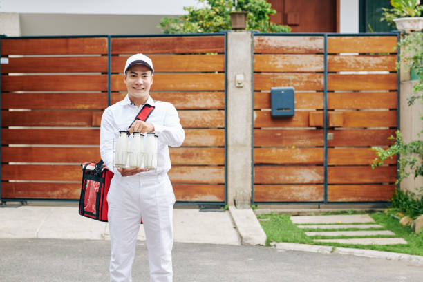 alegre repartidor con botellas de leche - milkman fotografías e imágenes de stock