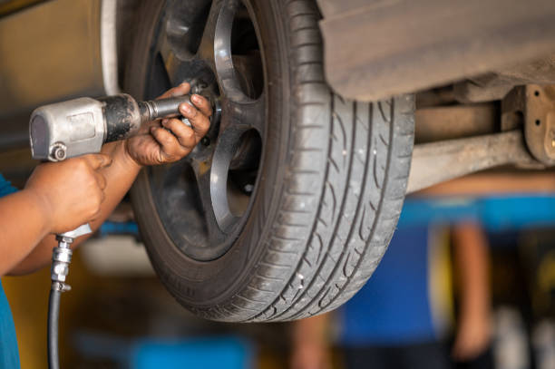 istock serviceman Using a wheel removing device at car repair service 1263547690