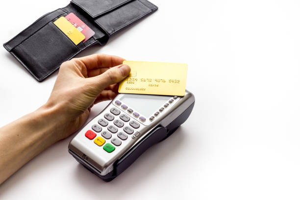 istock Payment by credit card. Hand hold card near terminal on white table copy space 1263551742