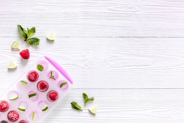 istock Ice cubes with berries and mint top view copy space 1263553120