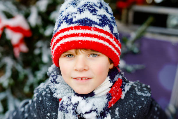 istock Funny little kid boy in colorful clothes playing outdoors during strong snowfall. Active leisure with children in winter on cold snowy days. Happy child having fun, playing with snow. Winter fashion. 1263553221