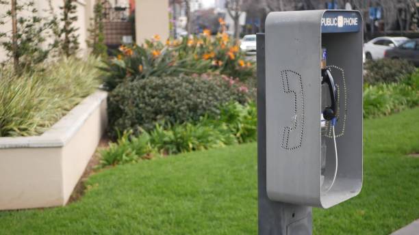 カリフォルニア州カリフォルニア州ストリートでの緊急通報のためのレトロなコイン式公衆電話ステーション。公共のアナログ公衆電話ブース。接続および通信サービスのための古い技術。� - coin operated pay phone telephone communication ストックフォトと画像