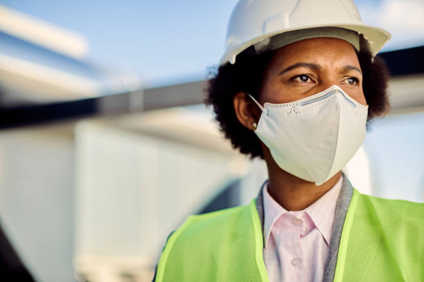 istock Female African American civil engineer with protective face mask at construction site. 1263556668