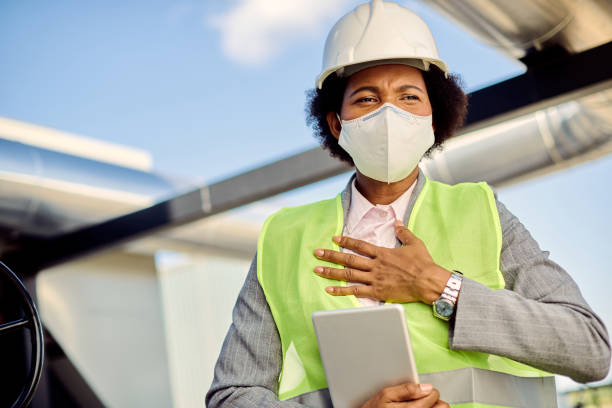 istock Black female building contractor with face mask feeling chest pain at construction site. 1263556719