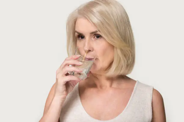 Photo of Mature woman hold glass enjoy pure mineral water
