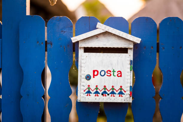 istock Rustic white wooden mailbox attached to painted picket fence 1263557910