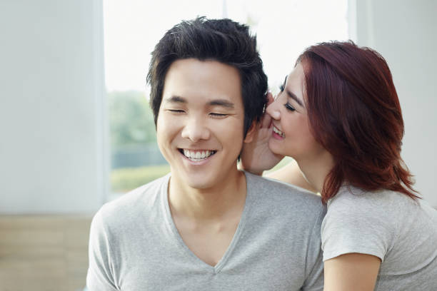 istock Girlfriend whispering to her boyfriend 1263559149