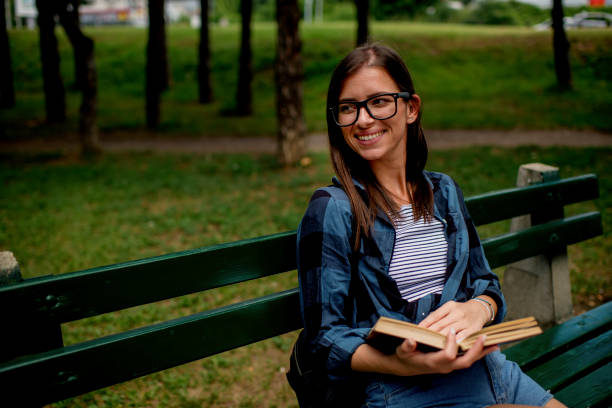 istock Young woman relaxing in nature with book 1263560757
