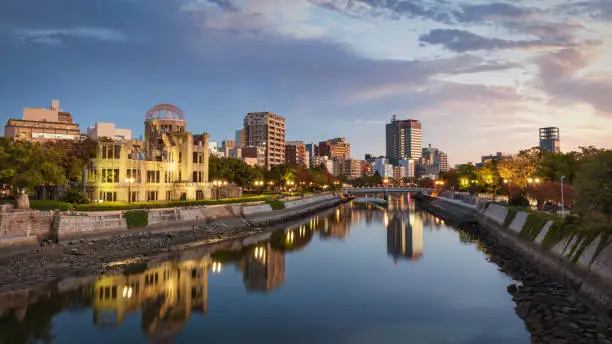 Hiroshima Atomic Bomb Dome Cityscape Panorama at Dusk Twilight. View over the River Ota close to Sunset. Buildings and Atomic Bomb Dome reflecting in the tranquil water of Ota River. Hiroshima, Japan, East Asia, Asia.